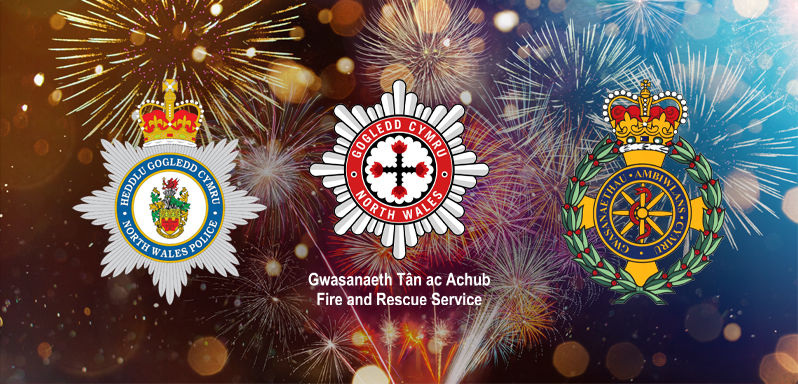 North Wales Police, North Wales Fire Service and Welsh Ambulance Services University NHS Trust logos over fireworks